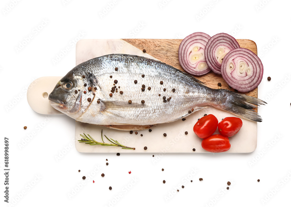 Board of raw dorado fish with onion and tomatoes on white background