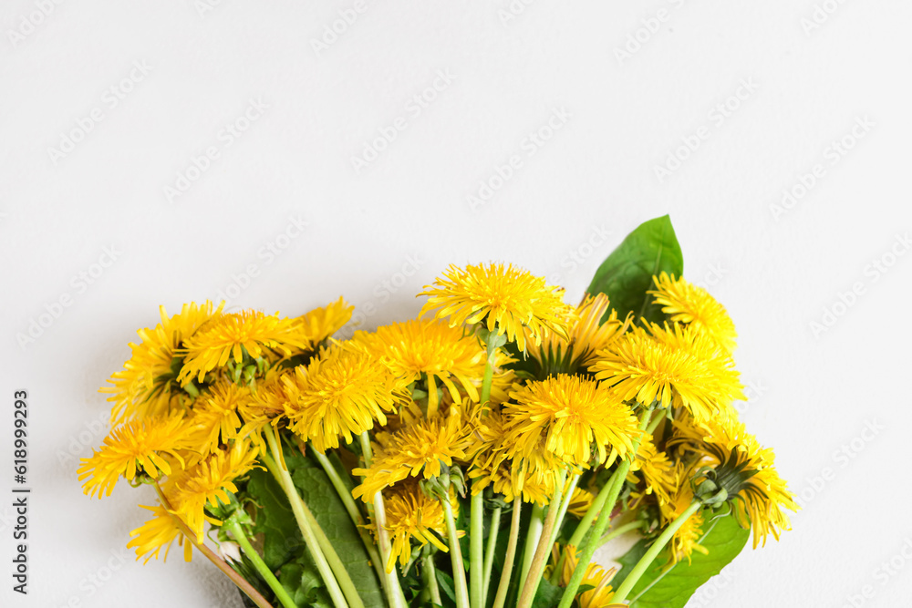 Bouquet of beautiful dandelion flowers on light background, closeup