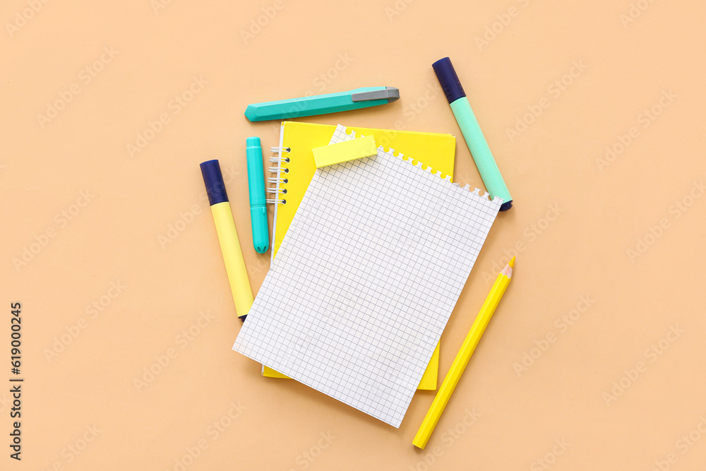 Blank notebook with different stationery on beige background