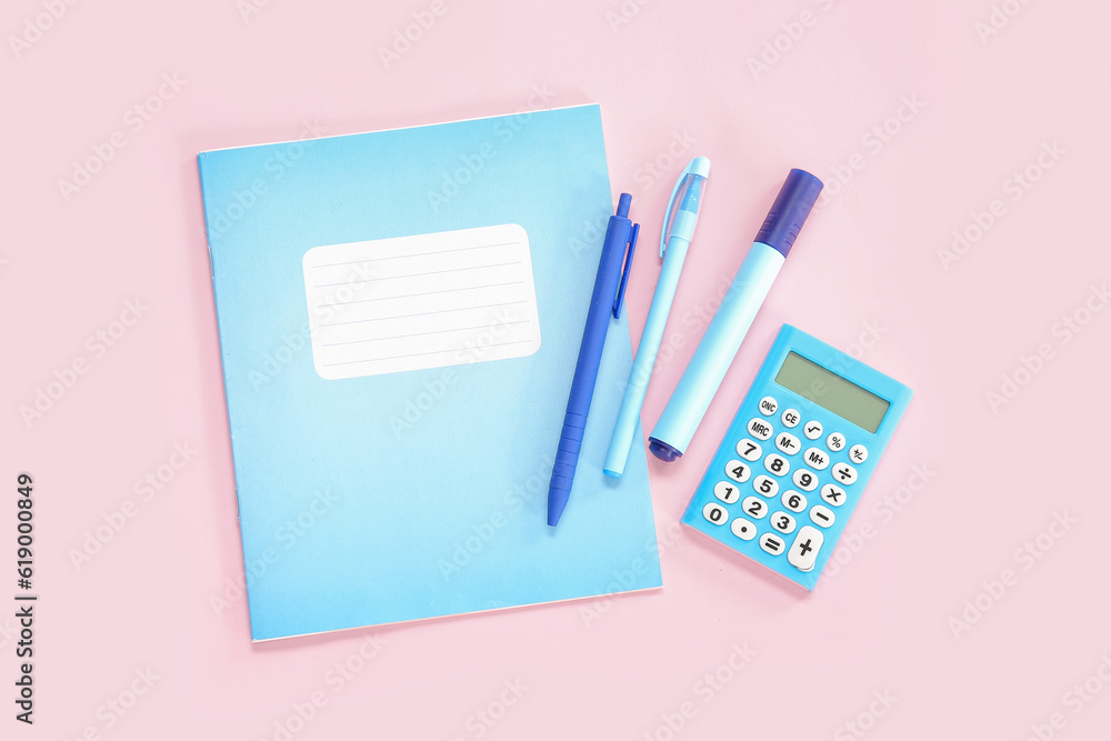 Notebook with different stationery on pink background