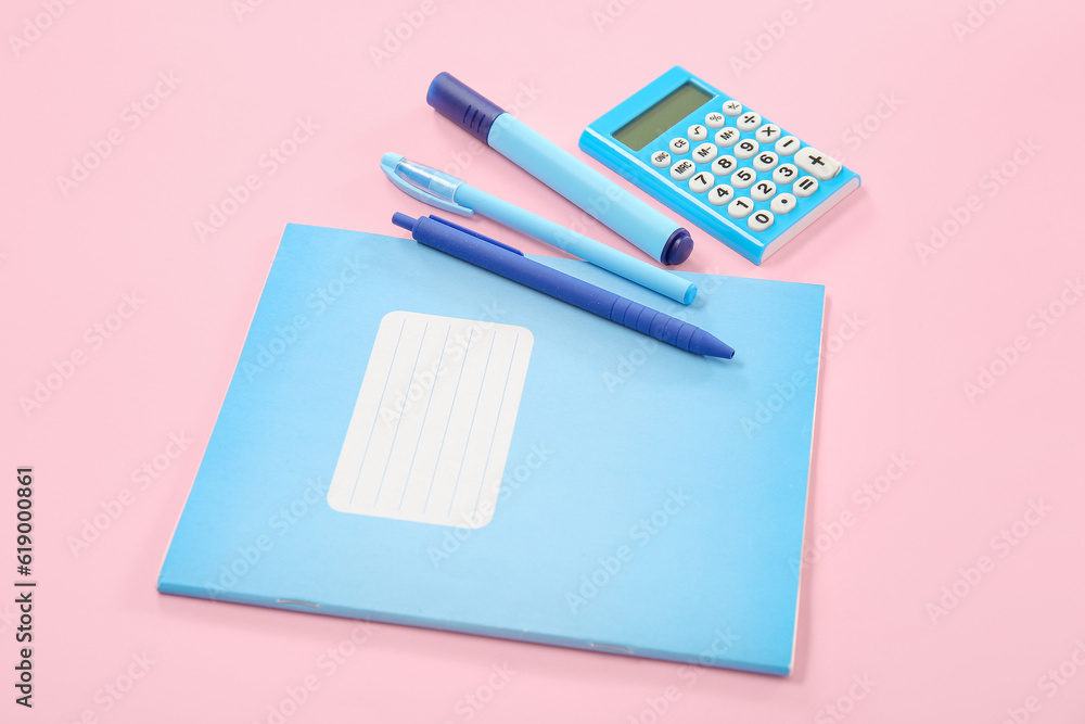 Notebook with different stationery on pink background