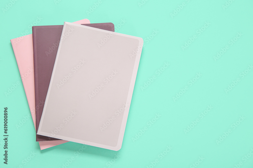 Different colorful notebooks on turquoise background