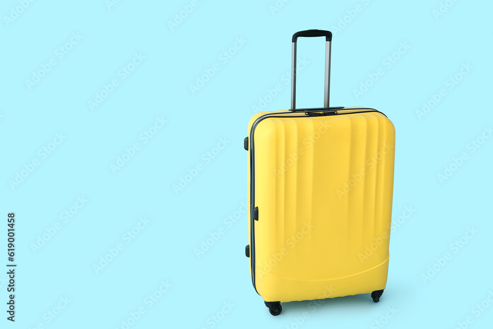 Yellow suitcase on blue background. Travel concept