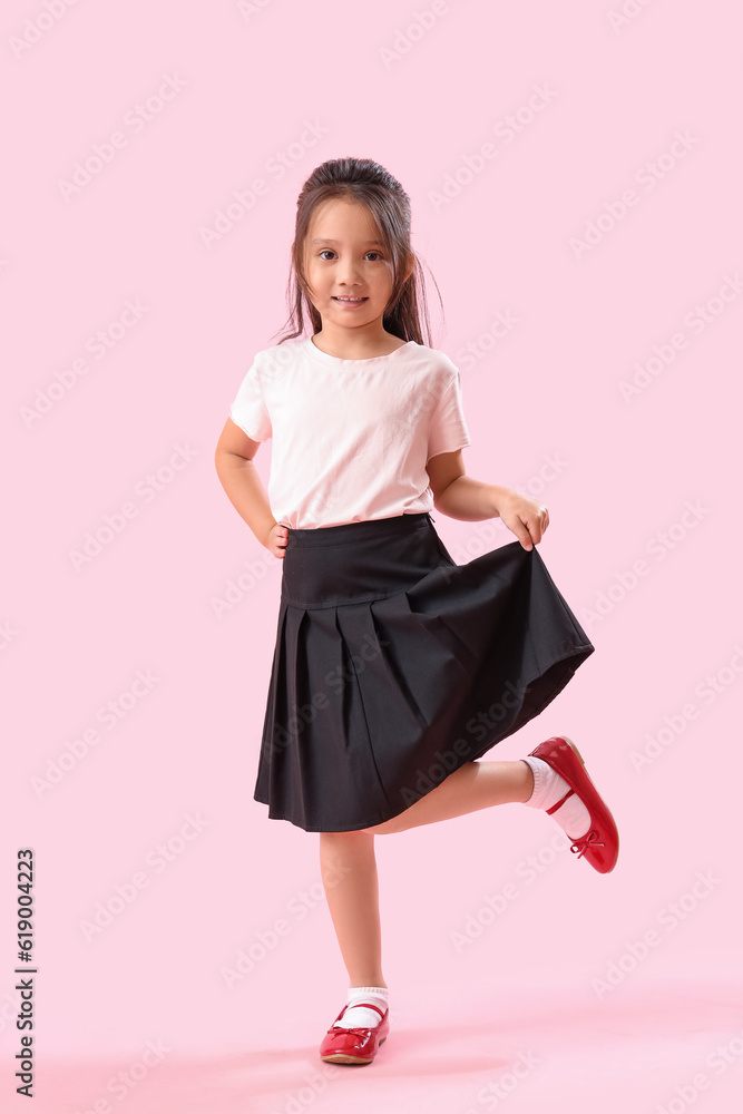 Little schoolgirl on pink background