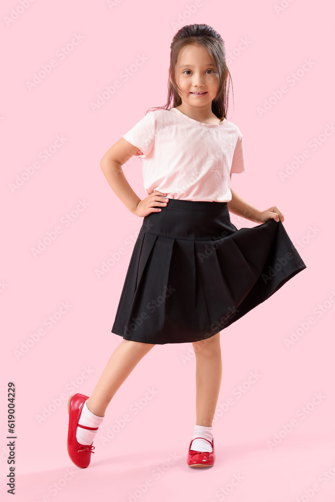 Little schoolgirl on pink background