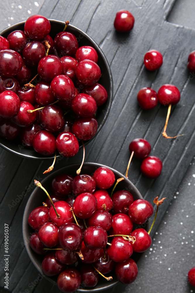 Board with bowls of sweet cherries, closeup