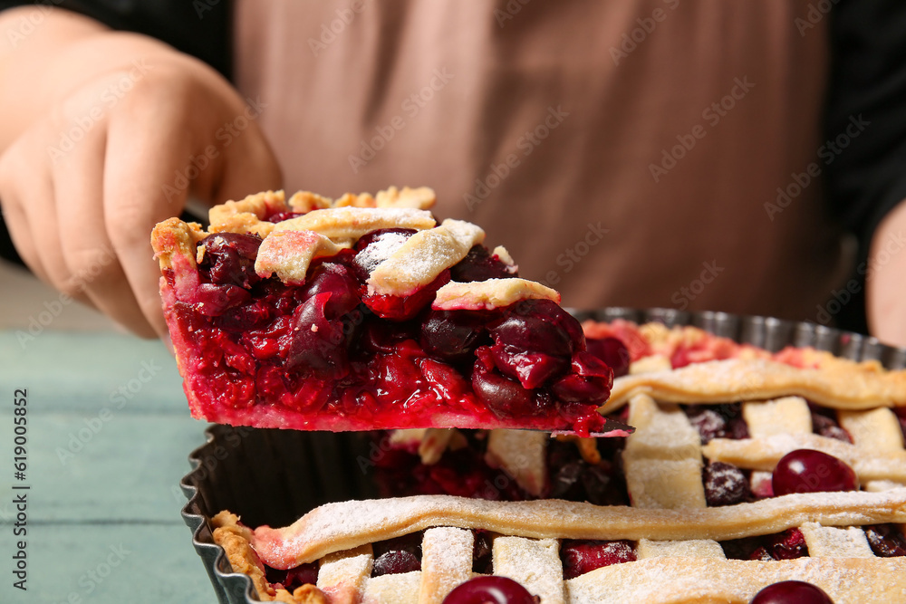 Woman taking piece of tasty cherry pie, closeup