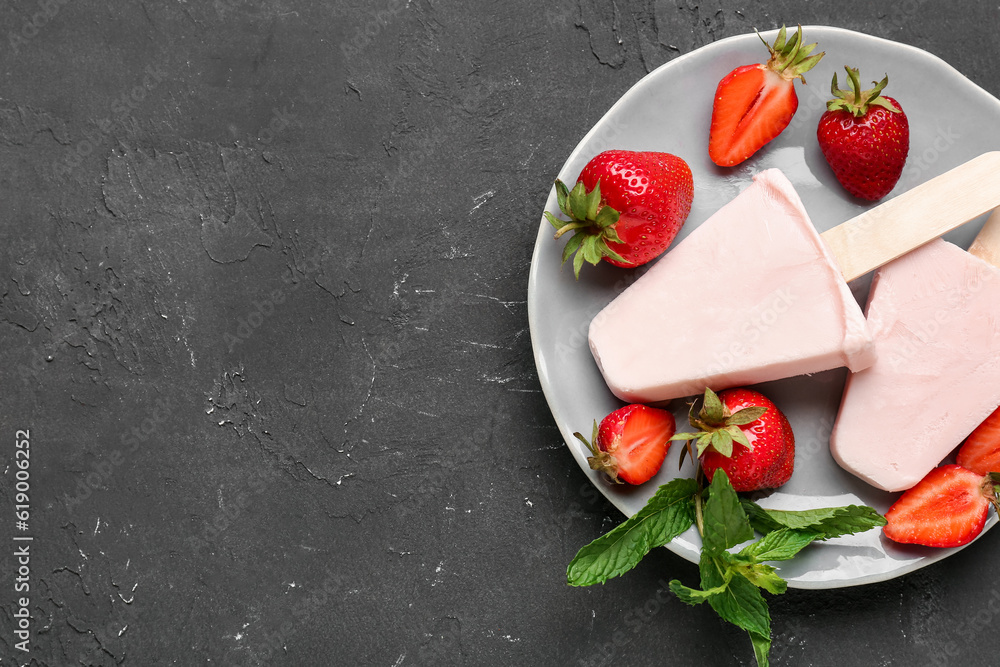 Plate with sweet strawberry ice-cream popsicles on black background