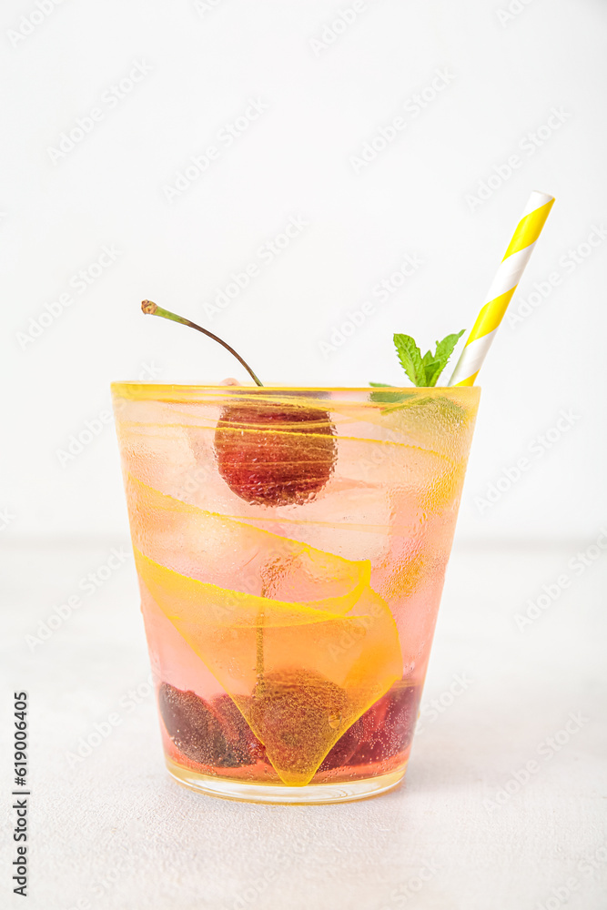 Glass of tasty cherry lemonade with mint on white background