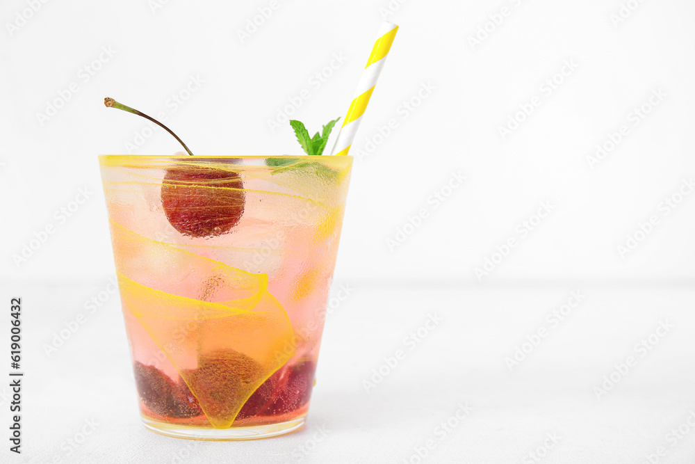 Glass of tasty cherry lemonade with mint on white background