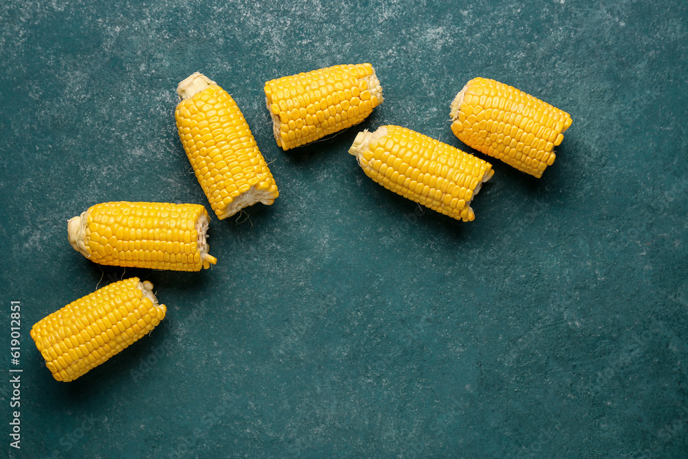 Cut fresh corn cobs on green background