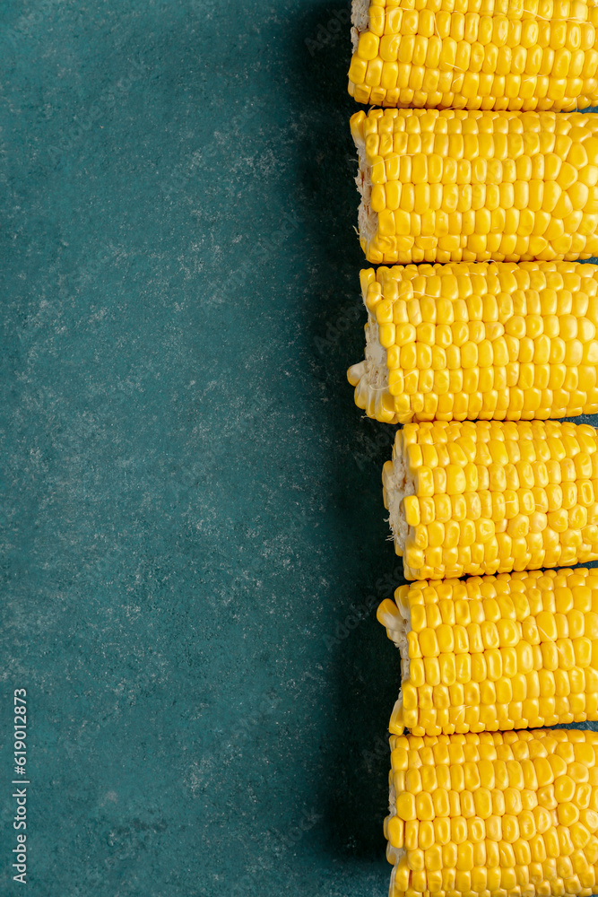 Cut fresh corn cobs on green background