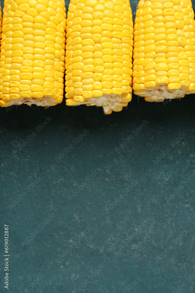 Cut fresh corn cobs on green background