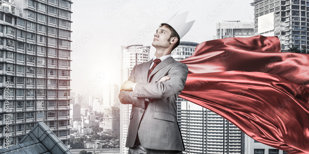 Concept of power and sucess with businessman superhero in big city