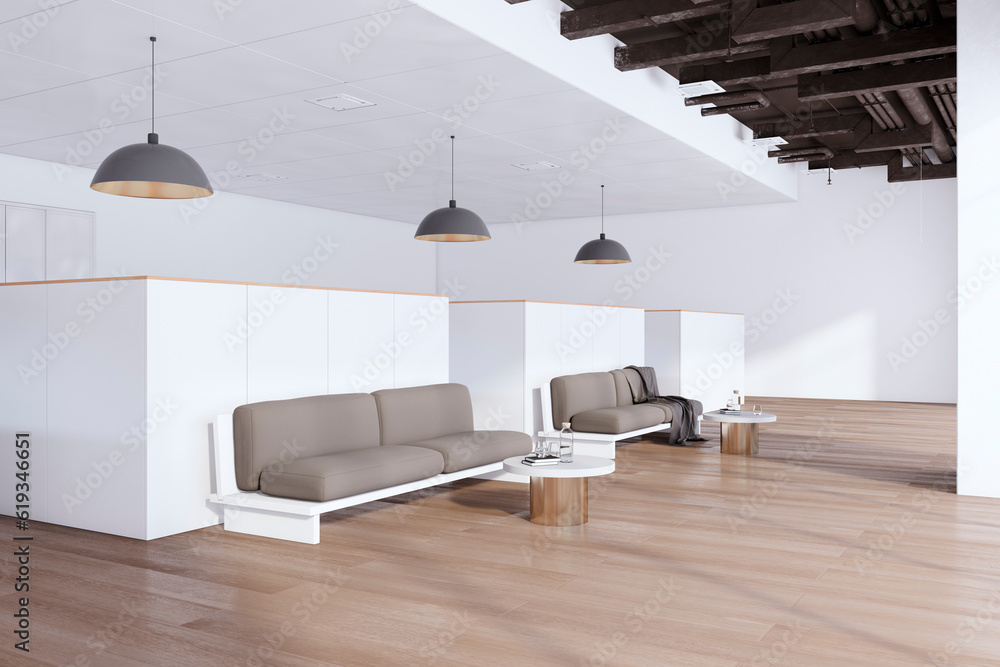 Bright coworking office interior with wooden flooring, partitions and waiting area couches with coff