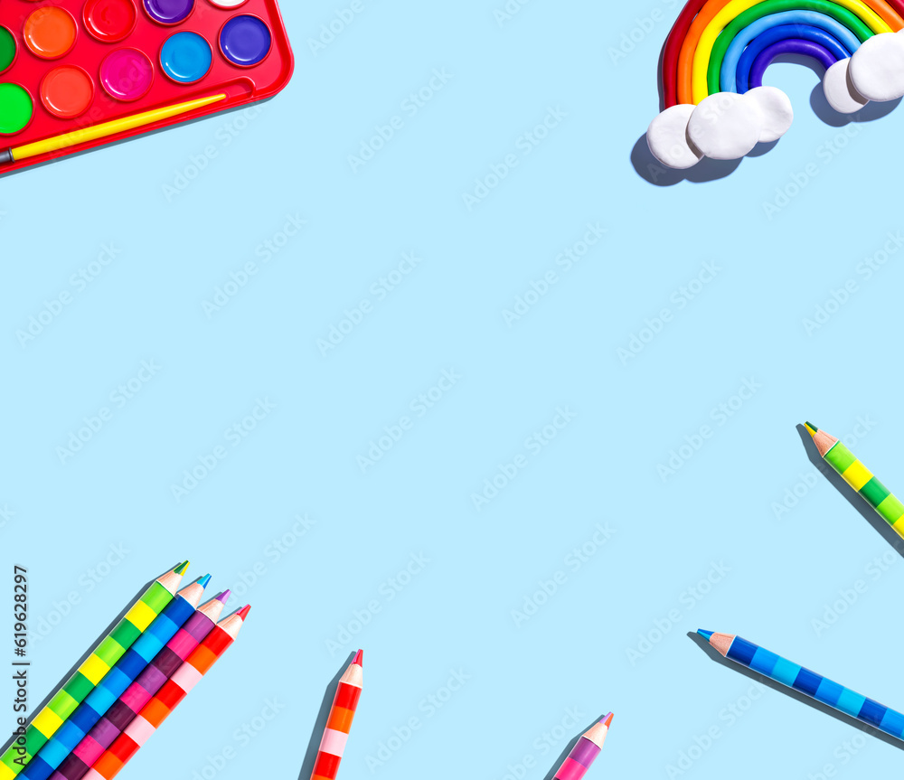 Art supplies with a rainbow - overhead view - flat lay