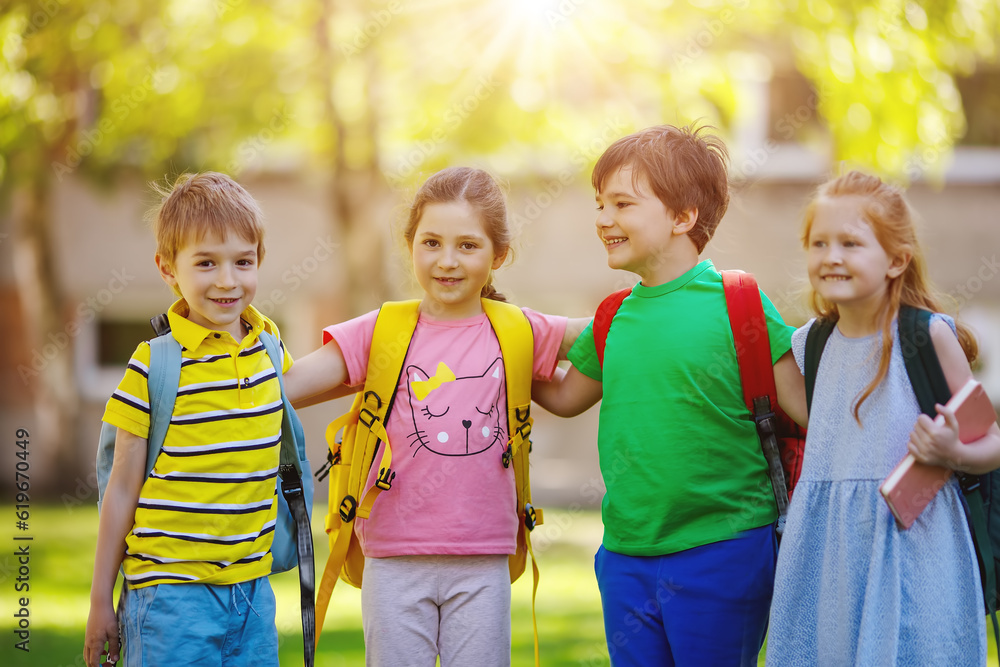 Group of children standing with backpacks near the school.