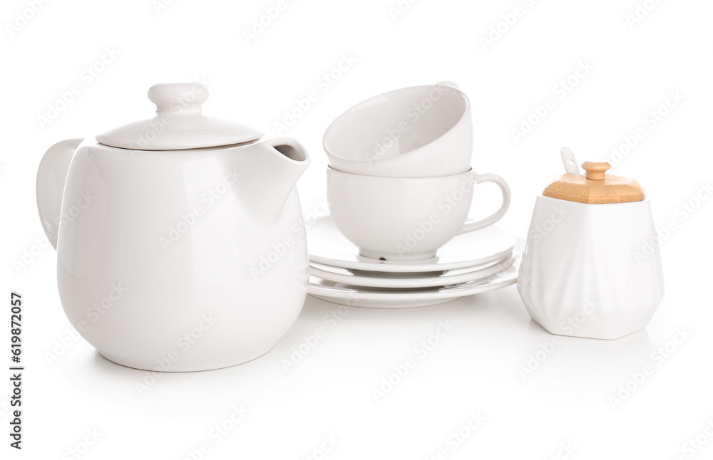 Ceramic teapot with cups, saucers and sugar bowl on white background