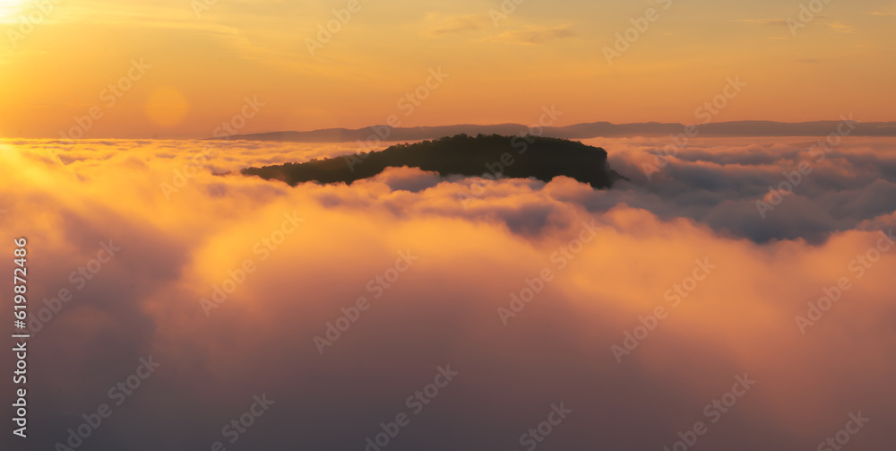 Aerial view of Morning sunrise above the mountains with mist around , Mountains fog and morning sun 