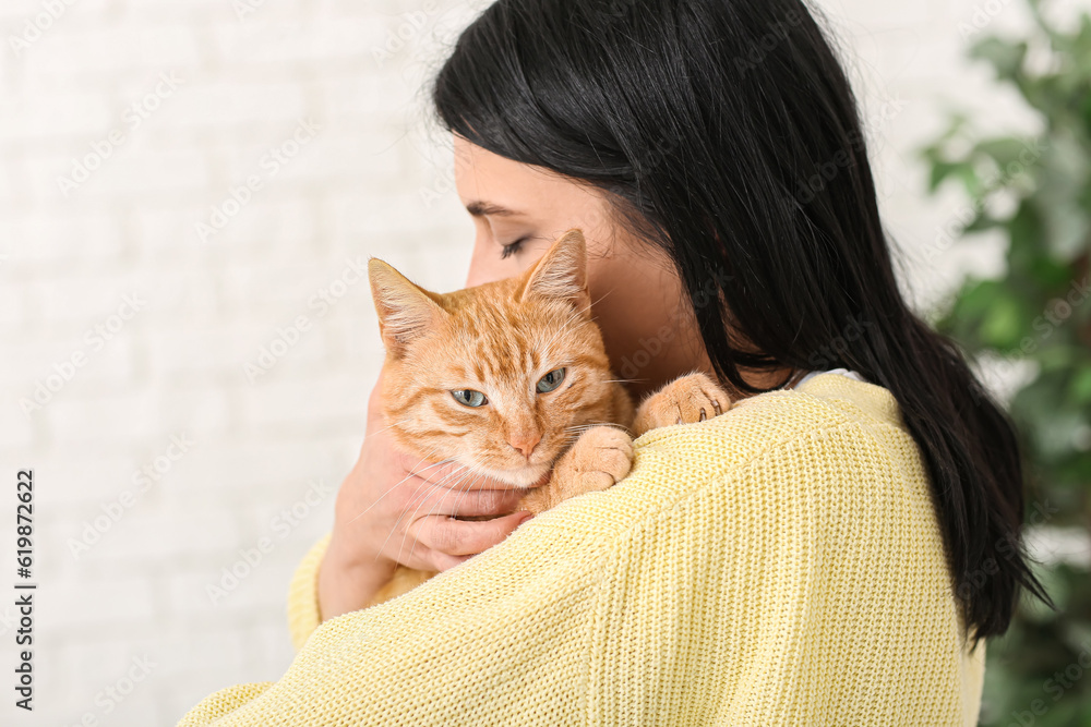 Woman with ginger cat at home, closeup