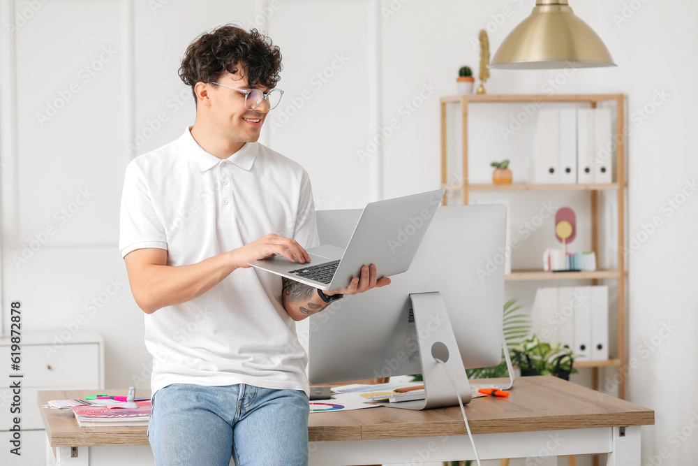 Male graphic designer working with laptop in office