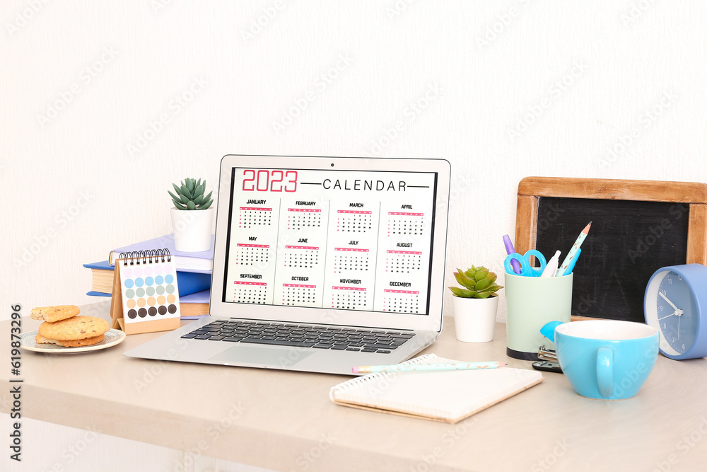 Modern laptop with calendar at workplace