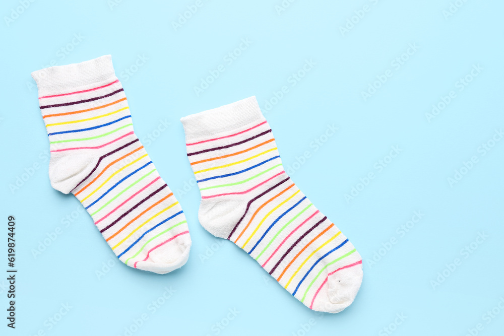 Pair of striped socks on color background