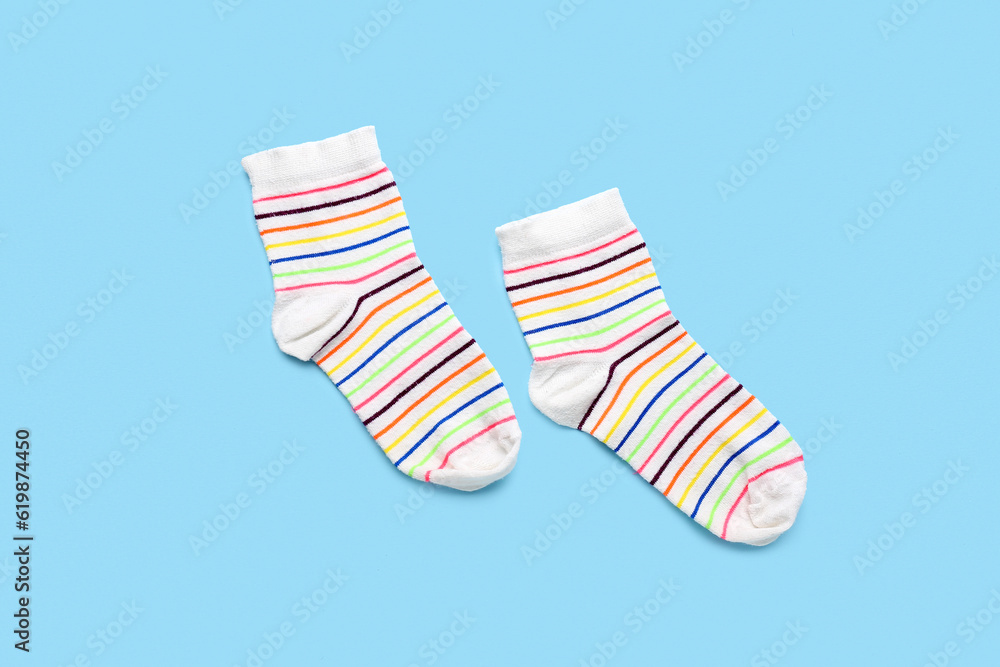 Pair of striped socks on color background