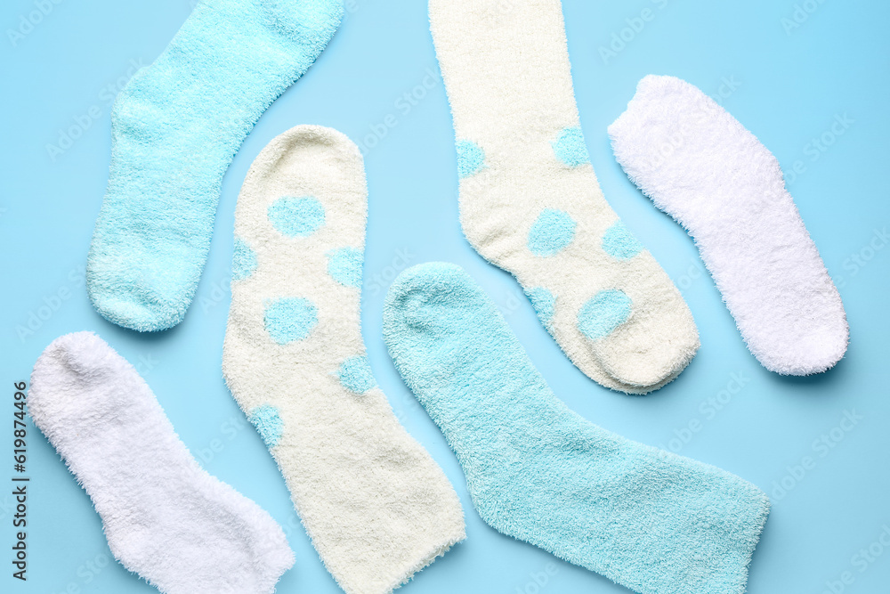 Set of warm socks on color background