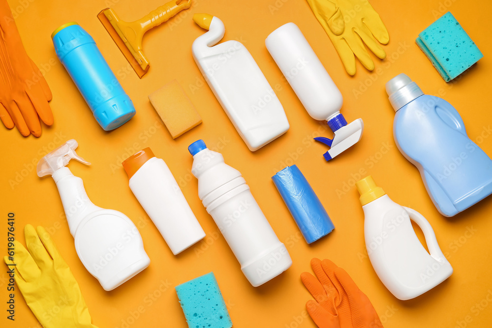 Different cleaning supplies on orange background