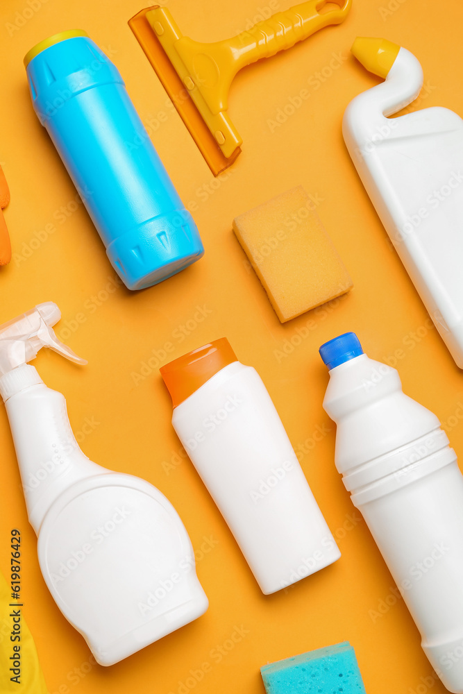 Different cleaning supplies on orange background