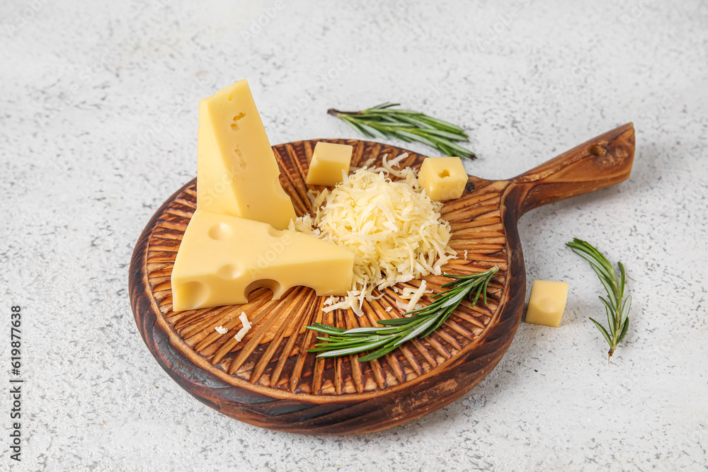 Wooden board with tasty Swiss cheese on light background