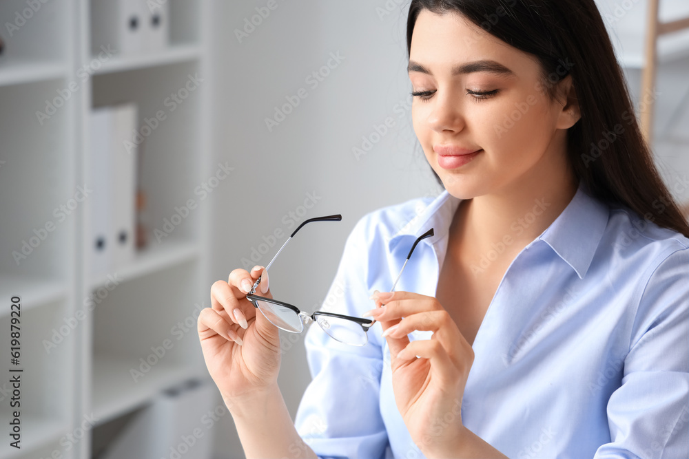 Beautiful young woman with glasses in office