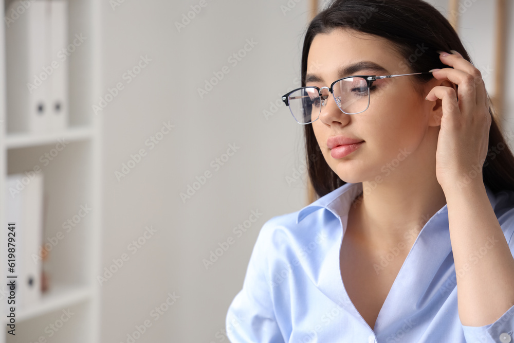 Beautiful young woman wearing glasses in office