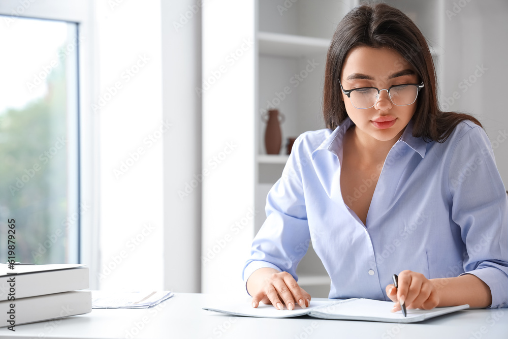 Beautiful young woman wearing glasses while working in office