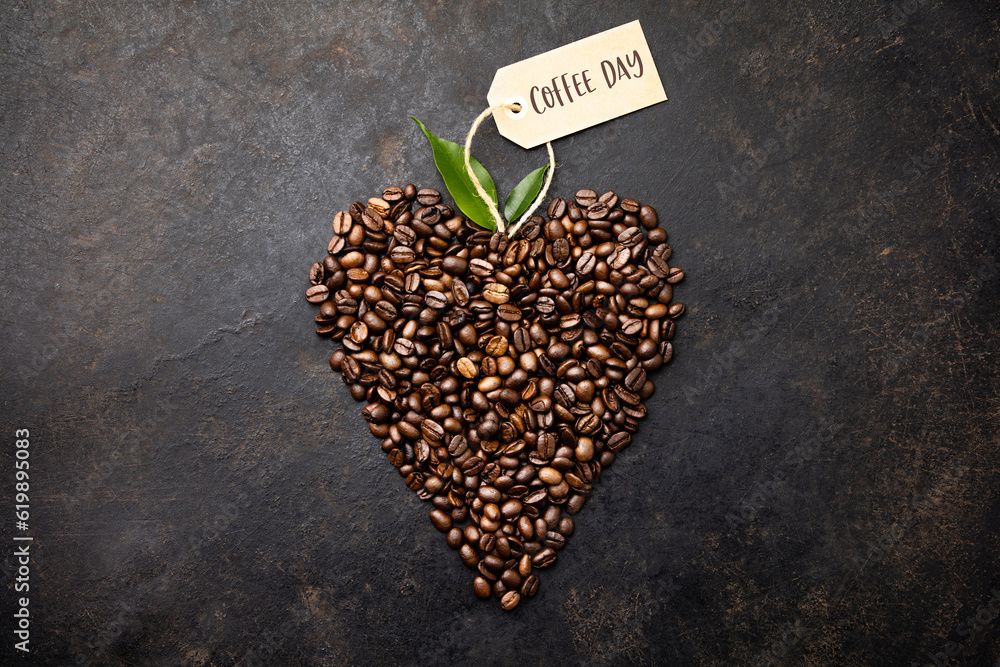 Coffee beans in shape of heart on dark rustic background