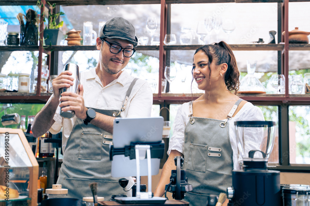 Asian attractive barista and Caucasian waitress working in coffeehouse. 