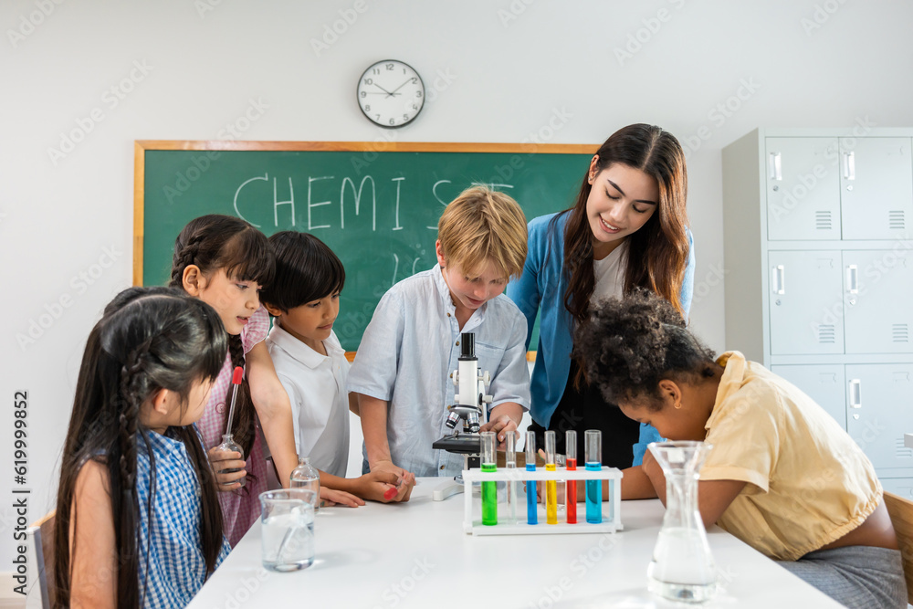 Adorable student learn with teacher in classroom at elementary school. 