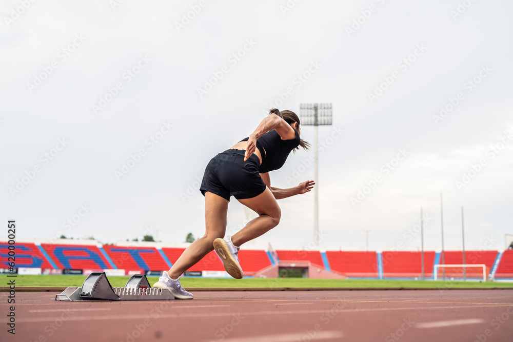 Asian young sportswoman sprint on a running track outdoors on stadium. 