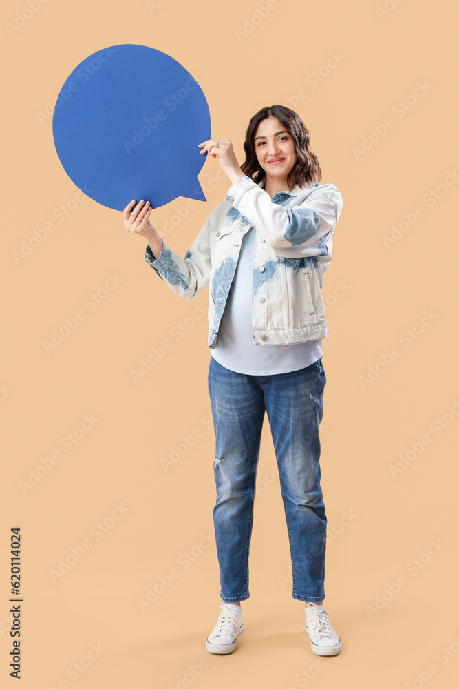 Young pregnant woman with blank speech bubble on beige background