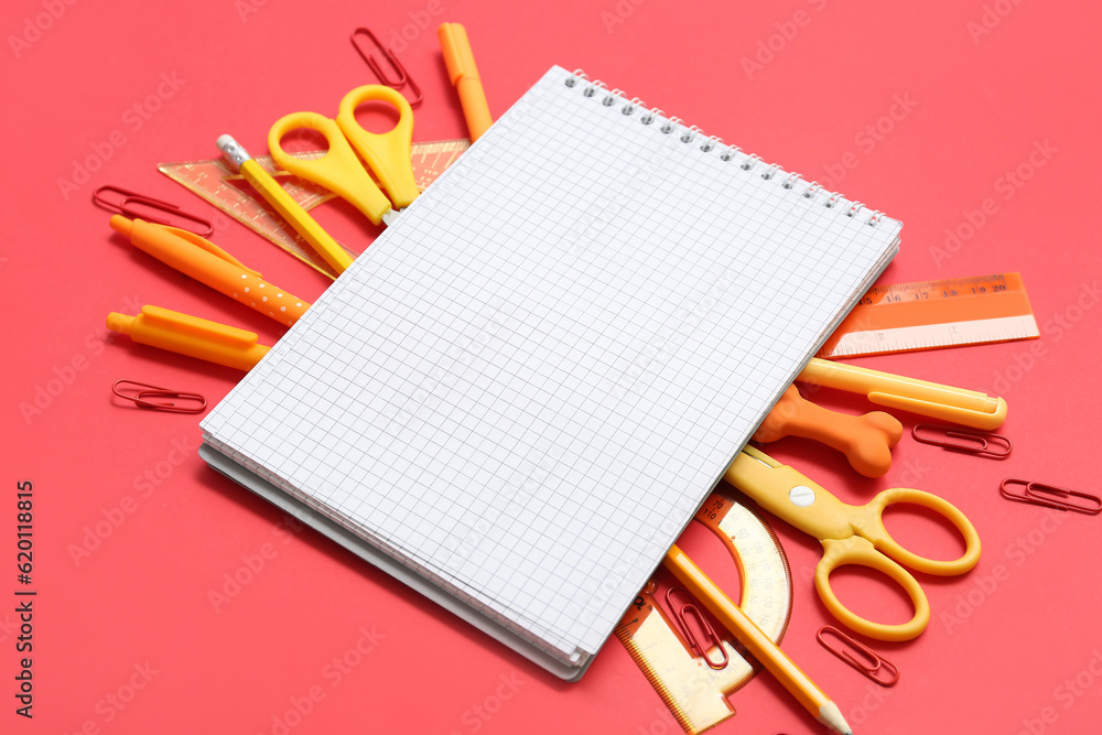 Composition with blank notebook and school stationery on red background, closeup