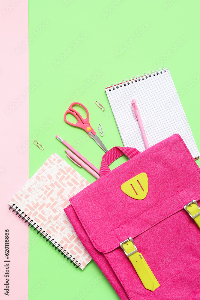 School backpack, notebooks and stationery on color background