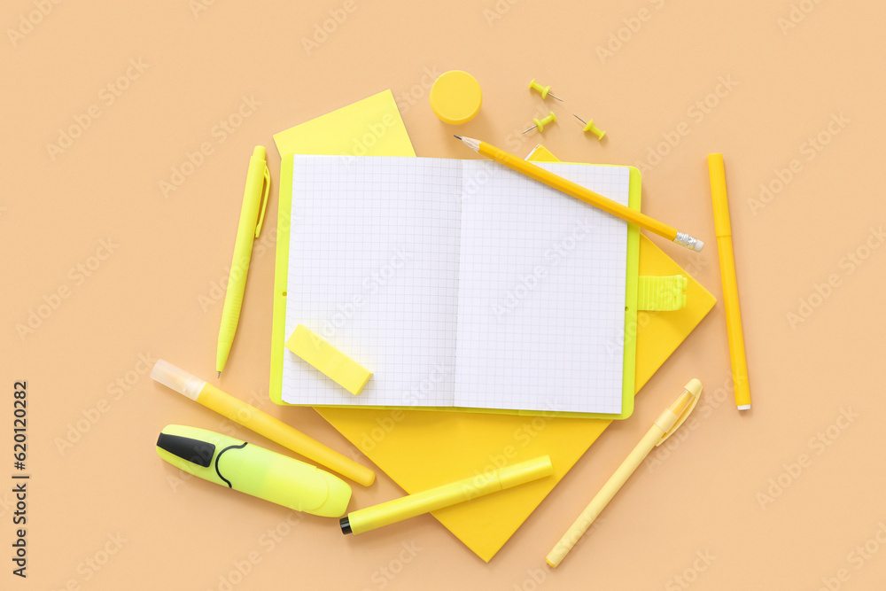 Blank notebook with different stationery on beige background