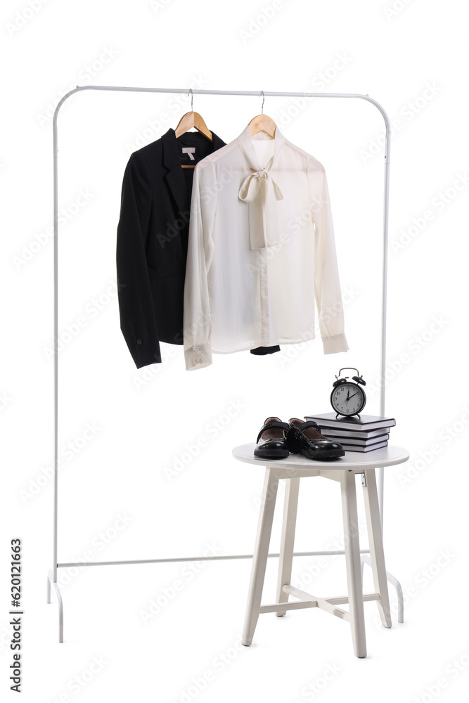 Rack with stylish school uniform, chair, books, alarm clock and shoes on white background