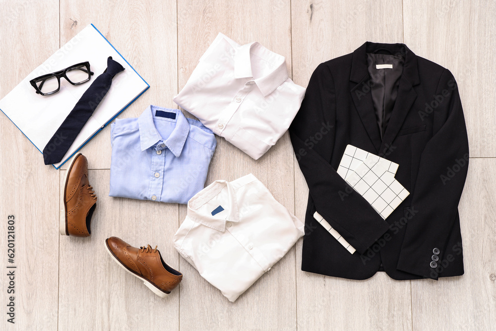 Composition with stylish school uniform, shoes, eyeglasses and tie on wooden background