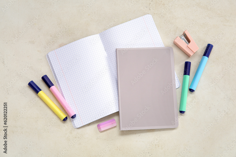 Notebooks with different stationery on beige background