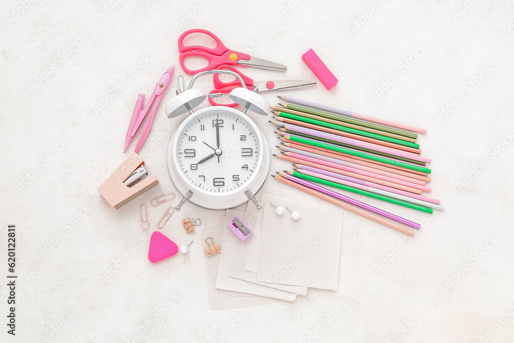 Alarm clock with different stationery on white background