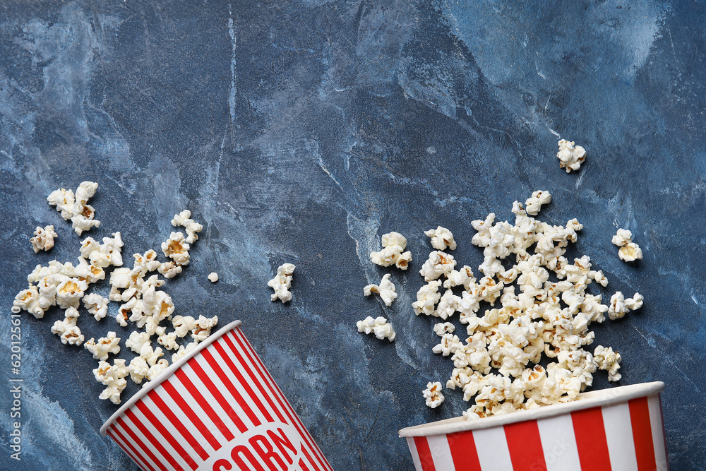 Buckets with tasty popcorn on blue background