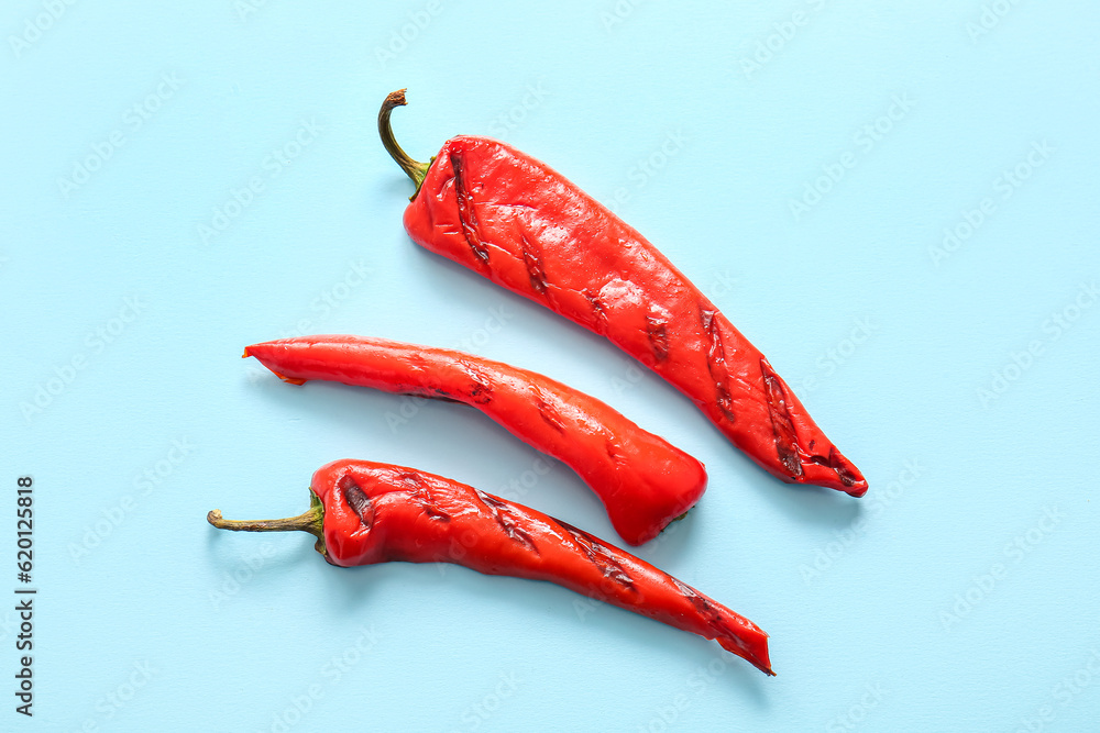 Tasty grilled chili pepper on blue background