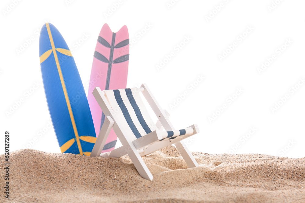 Mini surfboards with deckchair on sand against white background